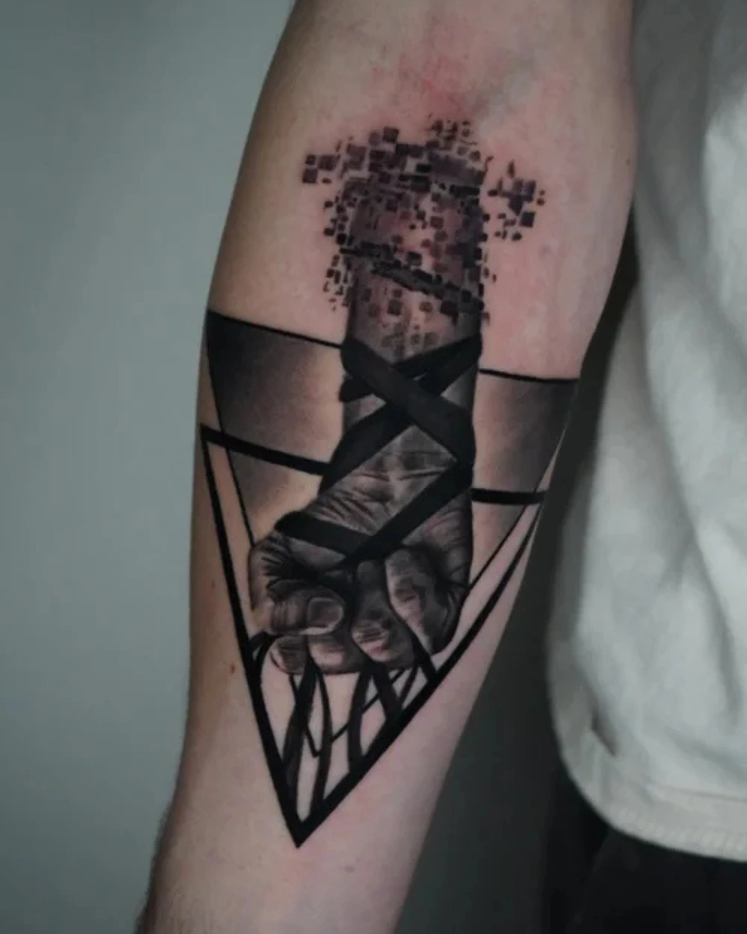 Surrealism tattoo of intertwined hands dissolving into geometric pixels blending realism with digital abstraction